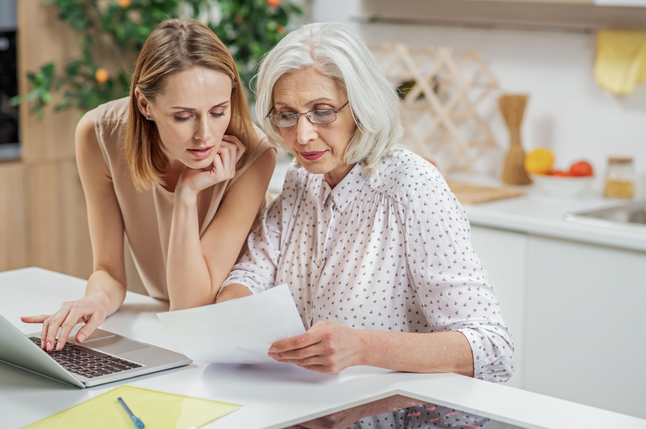 Senior woman and daughter reviewing financial documents