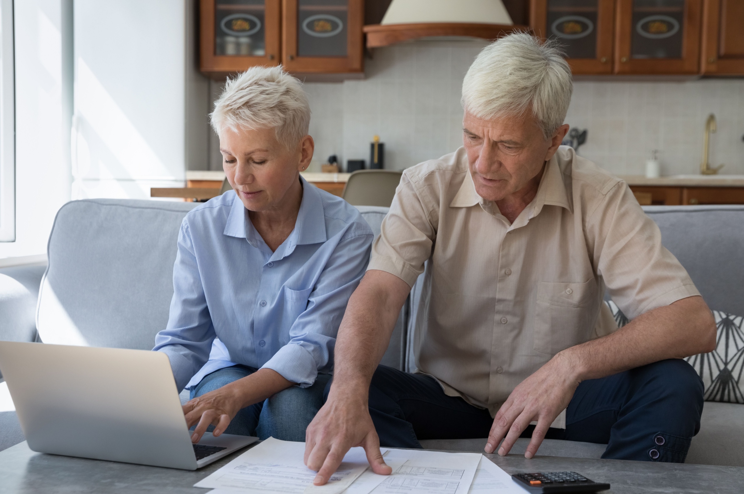 Senior couple looking at their finances on laptop